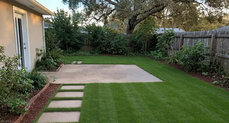 A manicured residential lawn with clean mow stripes and a crisp mechanical edge